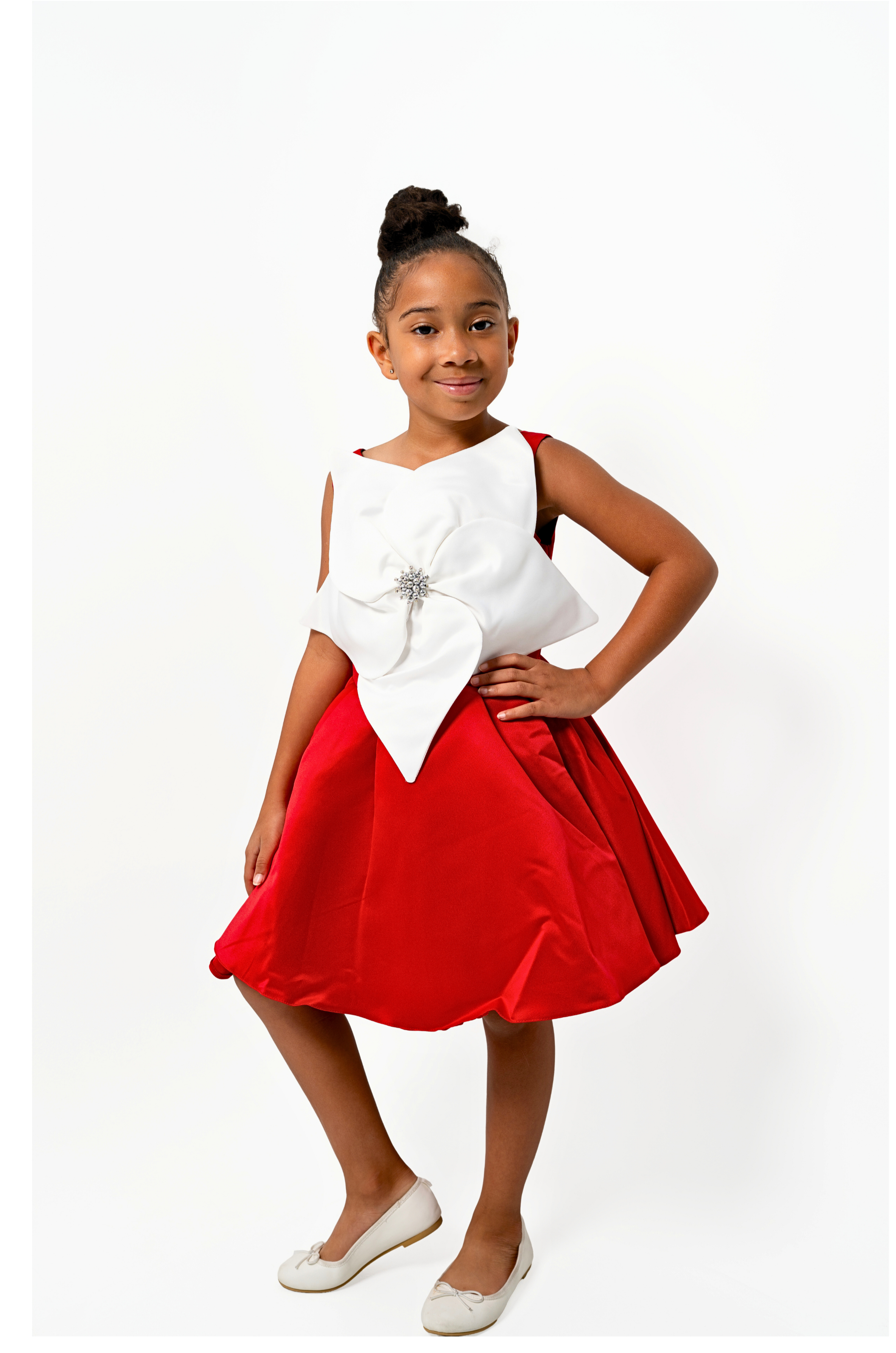 Girl wearing red holiday dress with white bow and brooch, ideal for Christmas or Valentine’s events